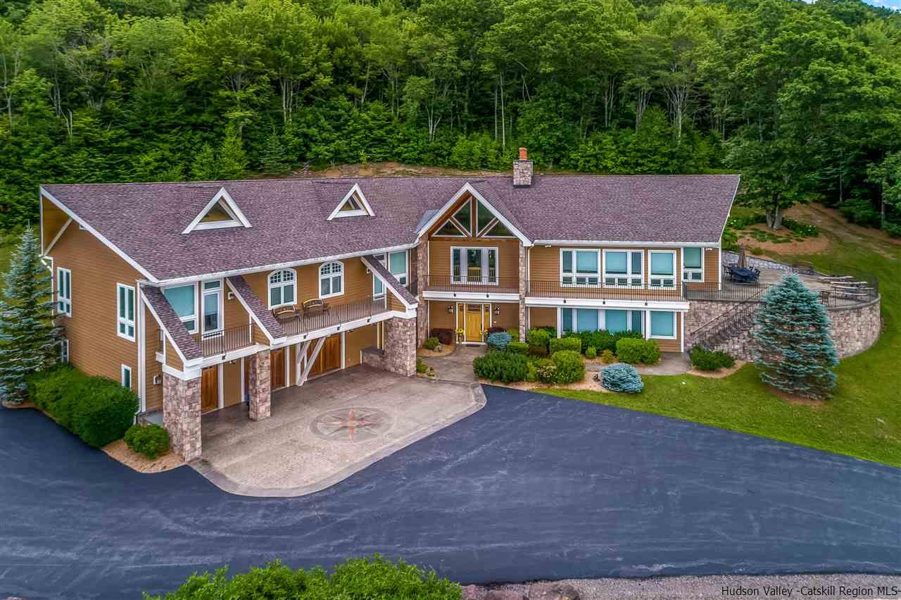 a front view of a house with a yard and a garden