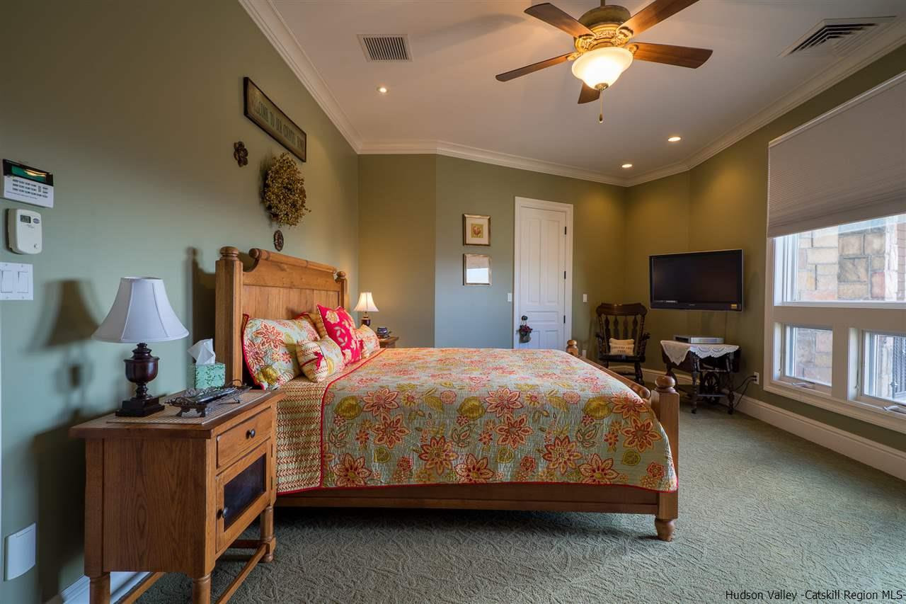 374 Kristins Ridge Road Margaretville, NY 12455 - Photo 18 of 33 a bedroom with a bed and a chandelier