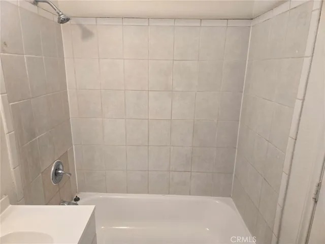 a bath tub sitting next to a white sink and a shower