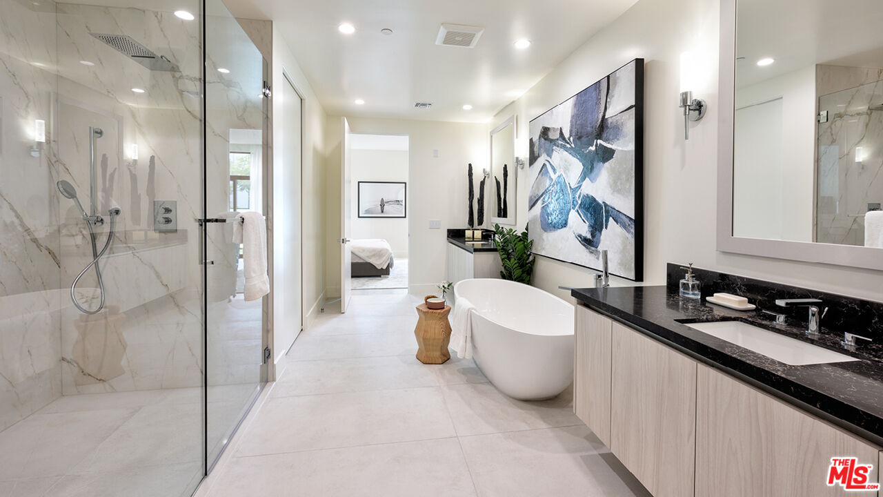 425 North Palm Drive, Unit 401 Beverly Hills, CA 90210 - Photo 5 of 22 a bathroom with a double vanity sink a toilet a mirror and shower