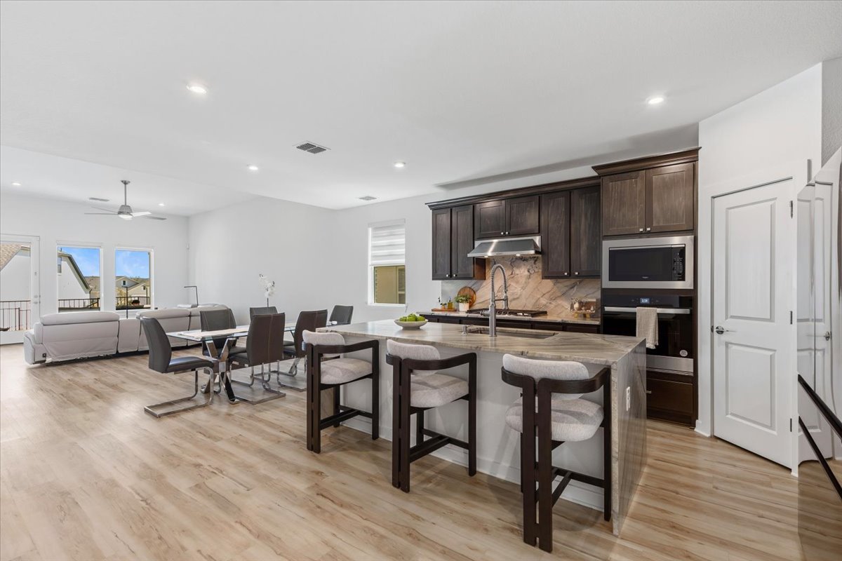 1904 Varese Path Leander, TX 78641 - Photo 12 of 40 a kitchen with stainless steel appliances a table chairs refrigerator and microwave
