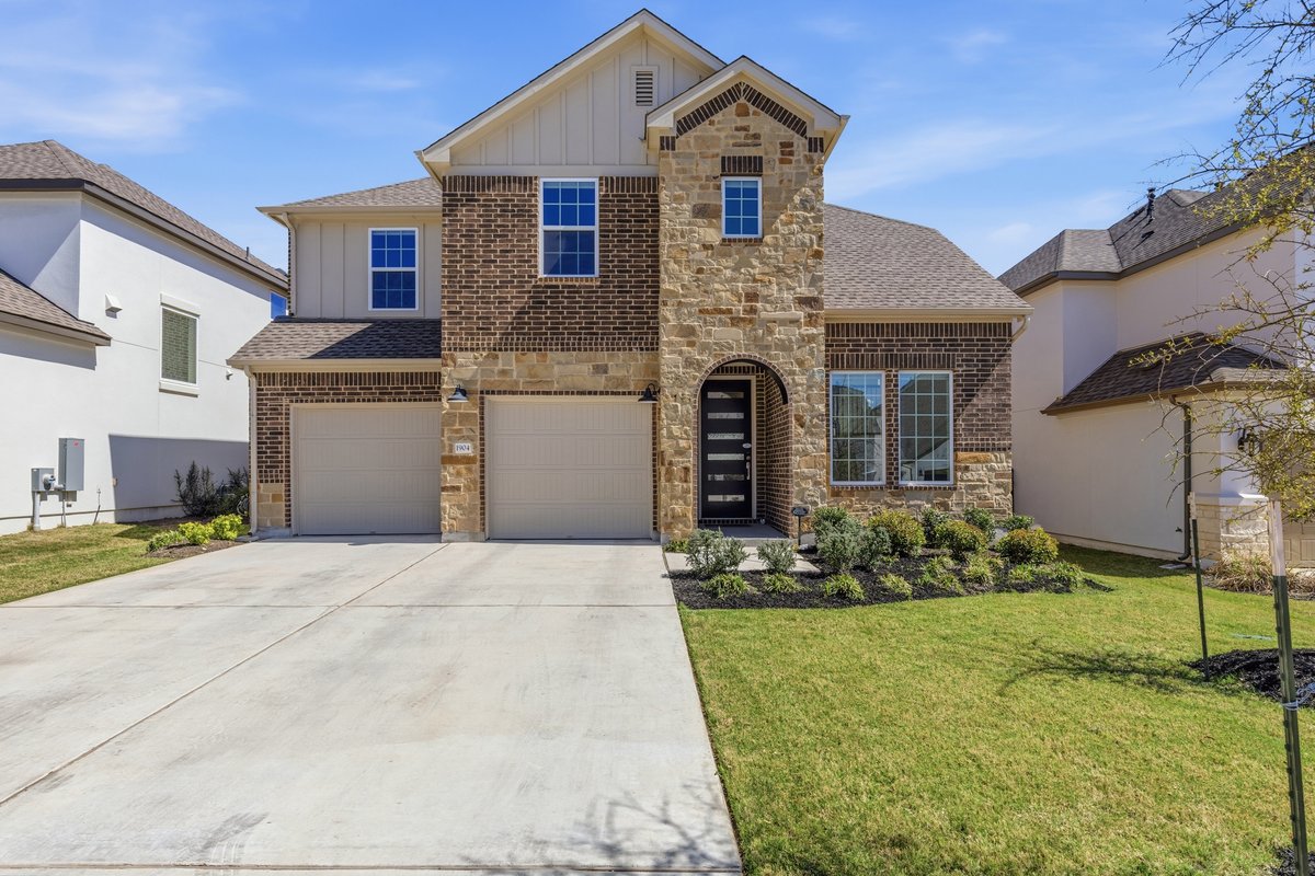 a front view of a house with a yard and garage