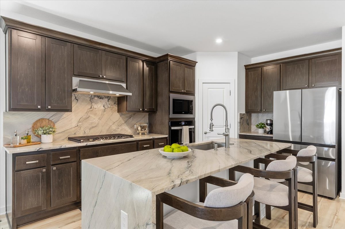 1904 Varese Path Leander, TX 78641 - Photo 7 of 40 a kitchen with granite countertop a sink cabinets and stainless steel appliances