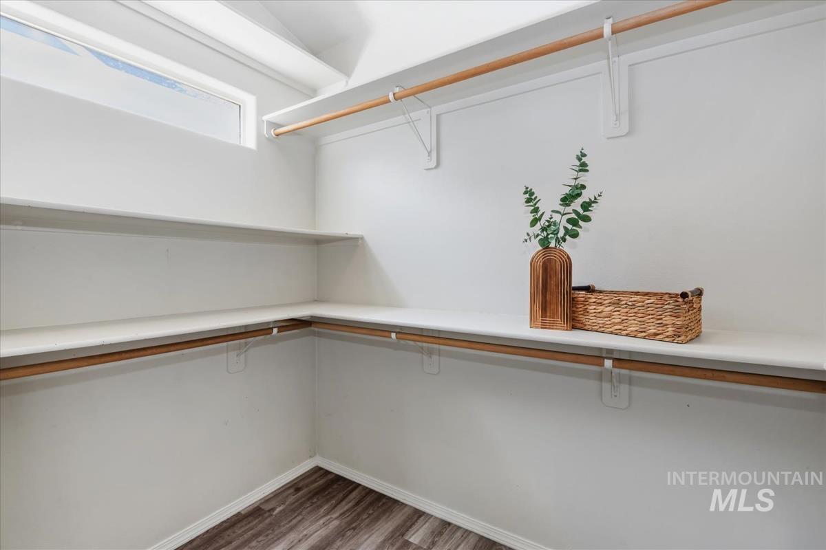 802 North Echohawk Way Eagle, ID 83616 - Photo 11 of 30 Spacious walk-in closet featuring wood-finish flooring, white walls, and built-in shelving