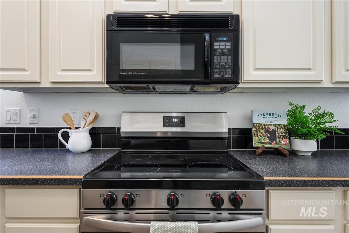802 North Echohawk Way Eagle, ID 83616 - Photo 16 of 30 Stainless steel range with a black ceramic cooktop, integrated oven, and overhead microwave