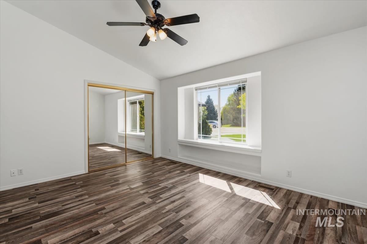 802 North Echohawk Way Eagle, ID 83616 - Photo 24 of 30 Vaulted ceiling room featuring wood-finish flooring, a ceiling fan with integrated lighting, mirrored sliding closet doors, and a window with a built-in sill