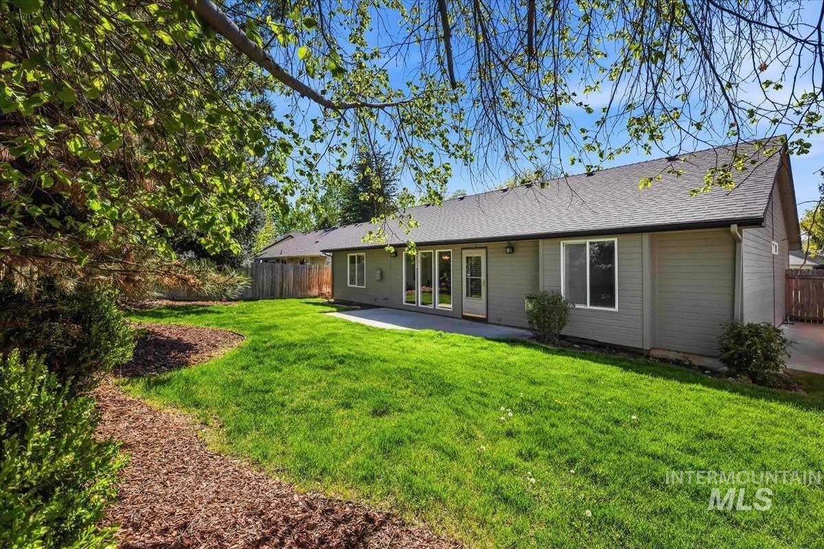 802 North Echohawk Way Eagle, ID 83616 - Photo 28 of 30 Rear exterior featuring gray siding, multiple windows, a glass-paneled door, and a concrete patio