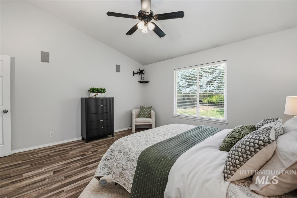 802 North Echohawk Way Eagle, ID 83616 - Photo 8 of 30 Vaulted ceiling bedroom featuring wood-finish flooring, a ceiling fan with light fixture, a large window with blinds, and built-in wall speakers