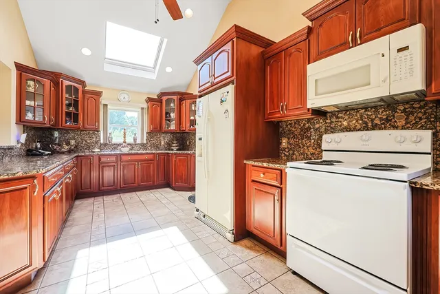 a kitchen with stainless steel appliances granite countertop a stove a refrigerator and a oven