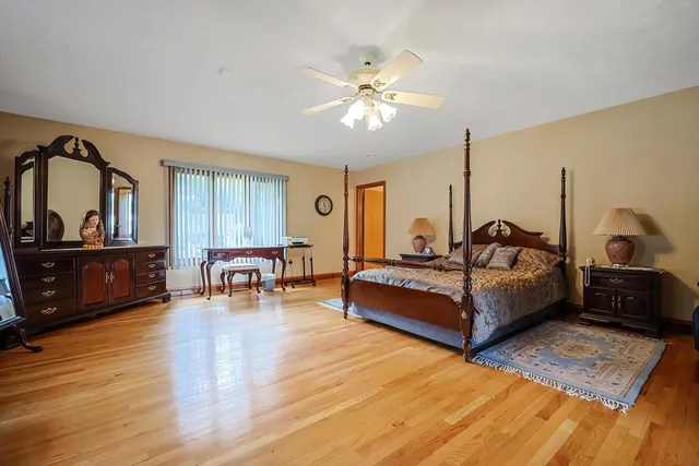 a bedroom with a bed a lamp on dresser and a chandelier
