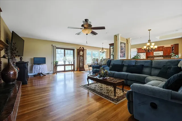 a living room with furniture a ceiling fan and a flat screen tv