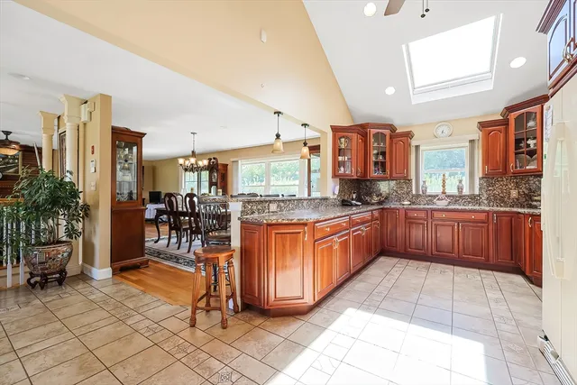 a large kitchen with stainless steel appliances granite countertop a stove a sink a dining table and chair