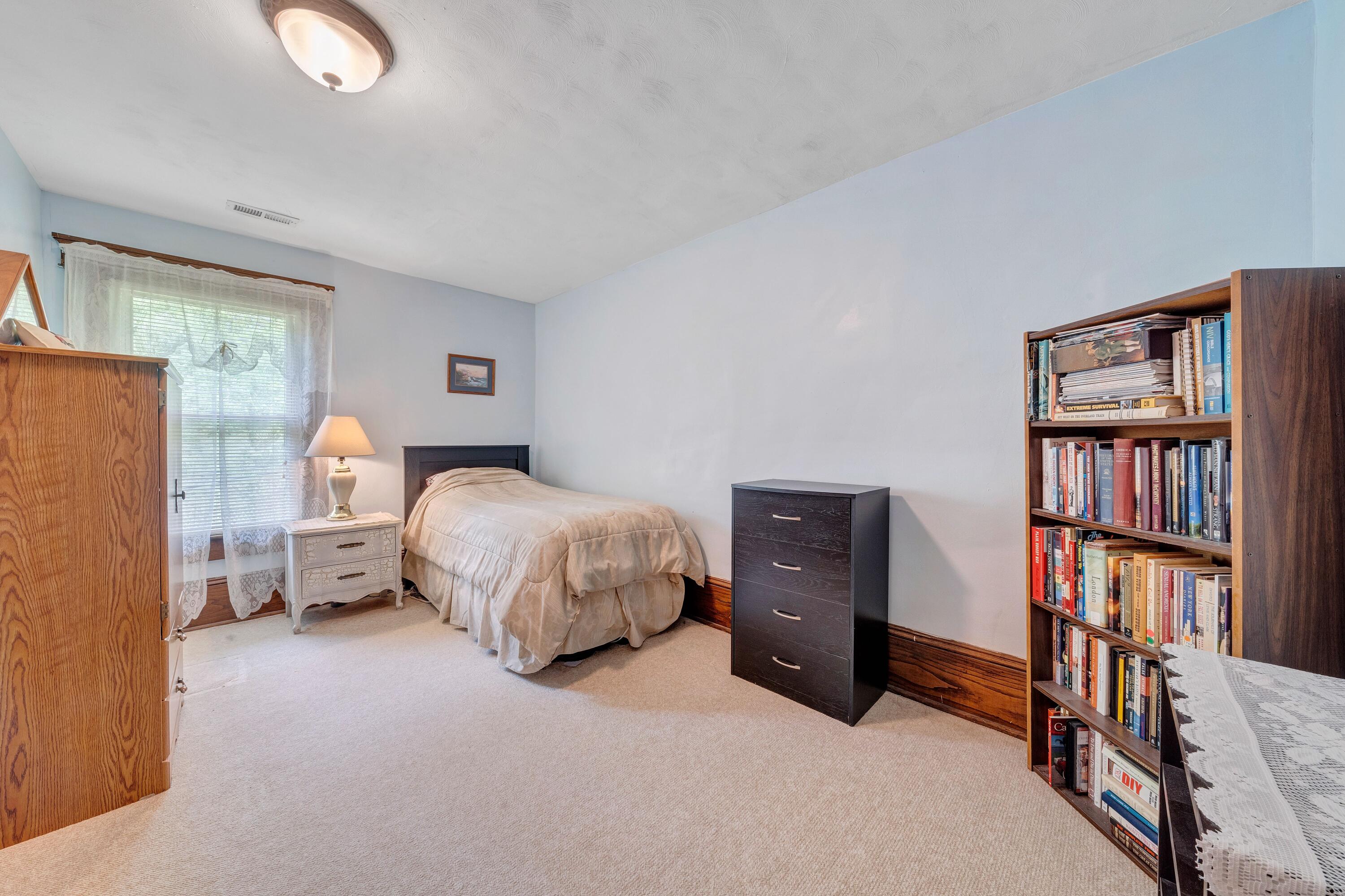 3759 Mill Iron Road Goodview, VA 24095 - Photo 30 of 39 a bedroom with a bed and a book shelf