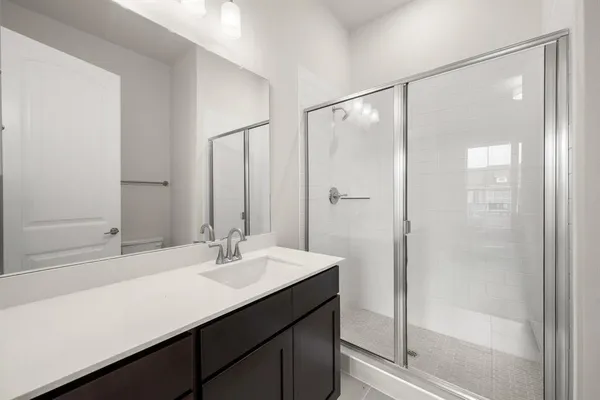 a bathroom with a shower sink and mirror