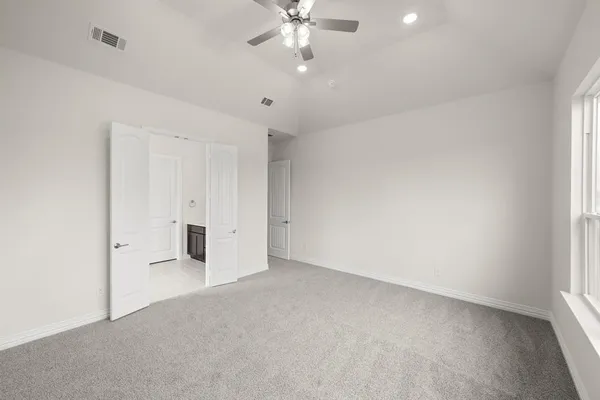 an empty room with a ceiling fan and a window