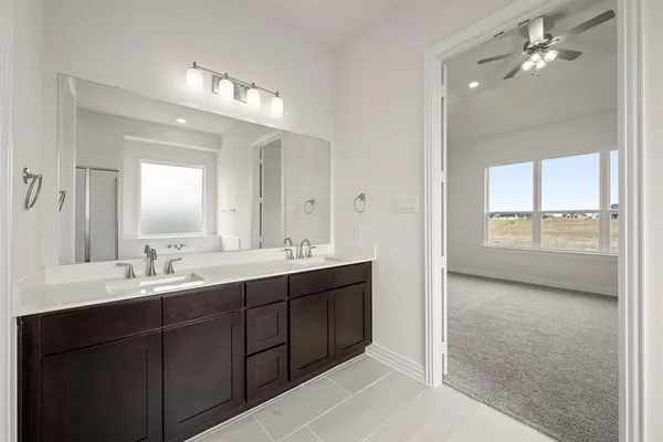 a bathroom with a double vanity sink mirror and next to a window