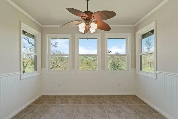 an empty room with a window and a fan
