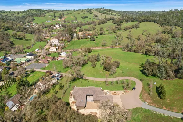 an aerial view of residential houses with outdoor space and trees