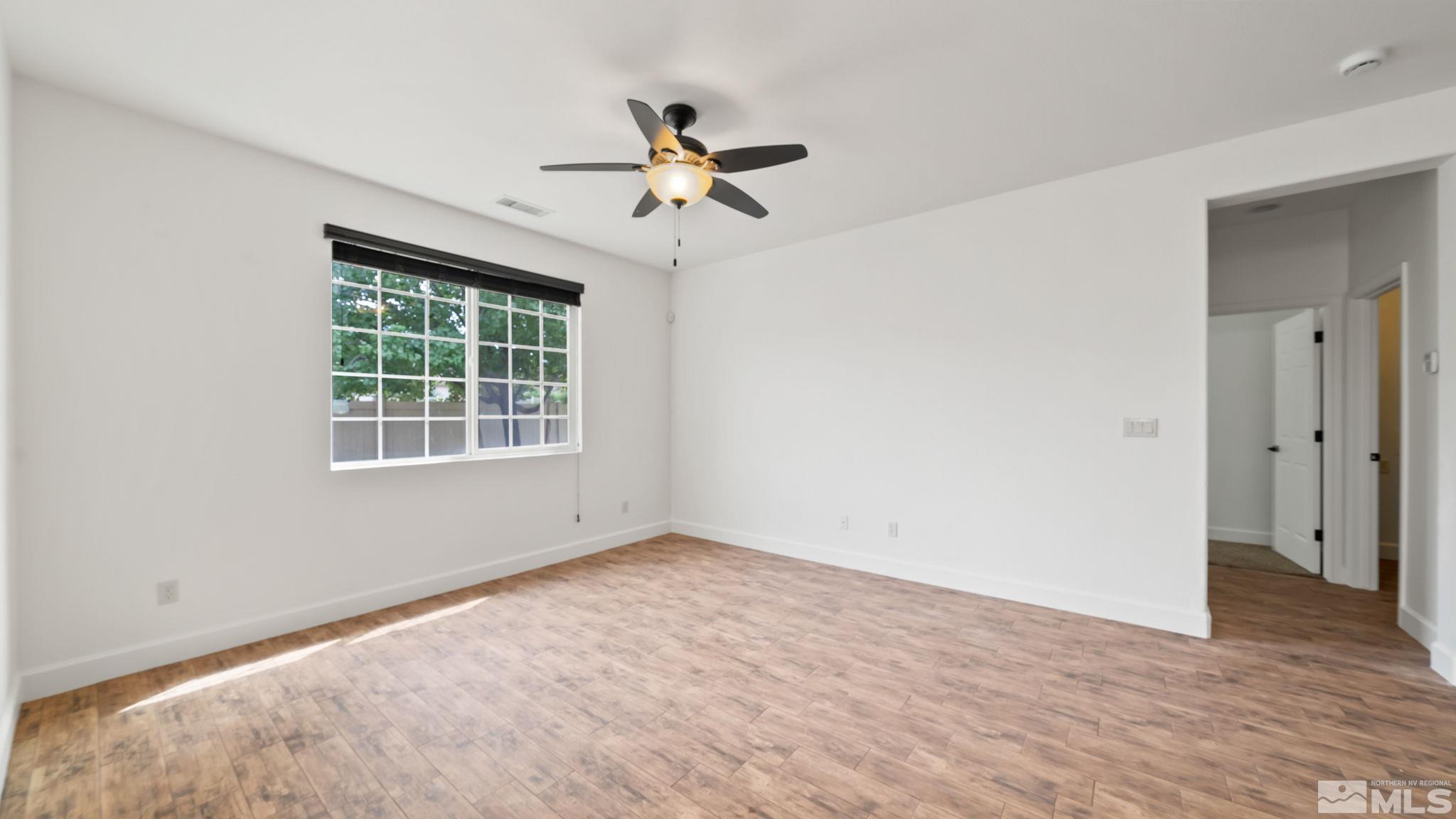 11074 Colton Drive Reno, NV 89521 - Photo 18 of 28 a view of empty room with wooden floor and fan