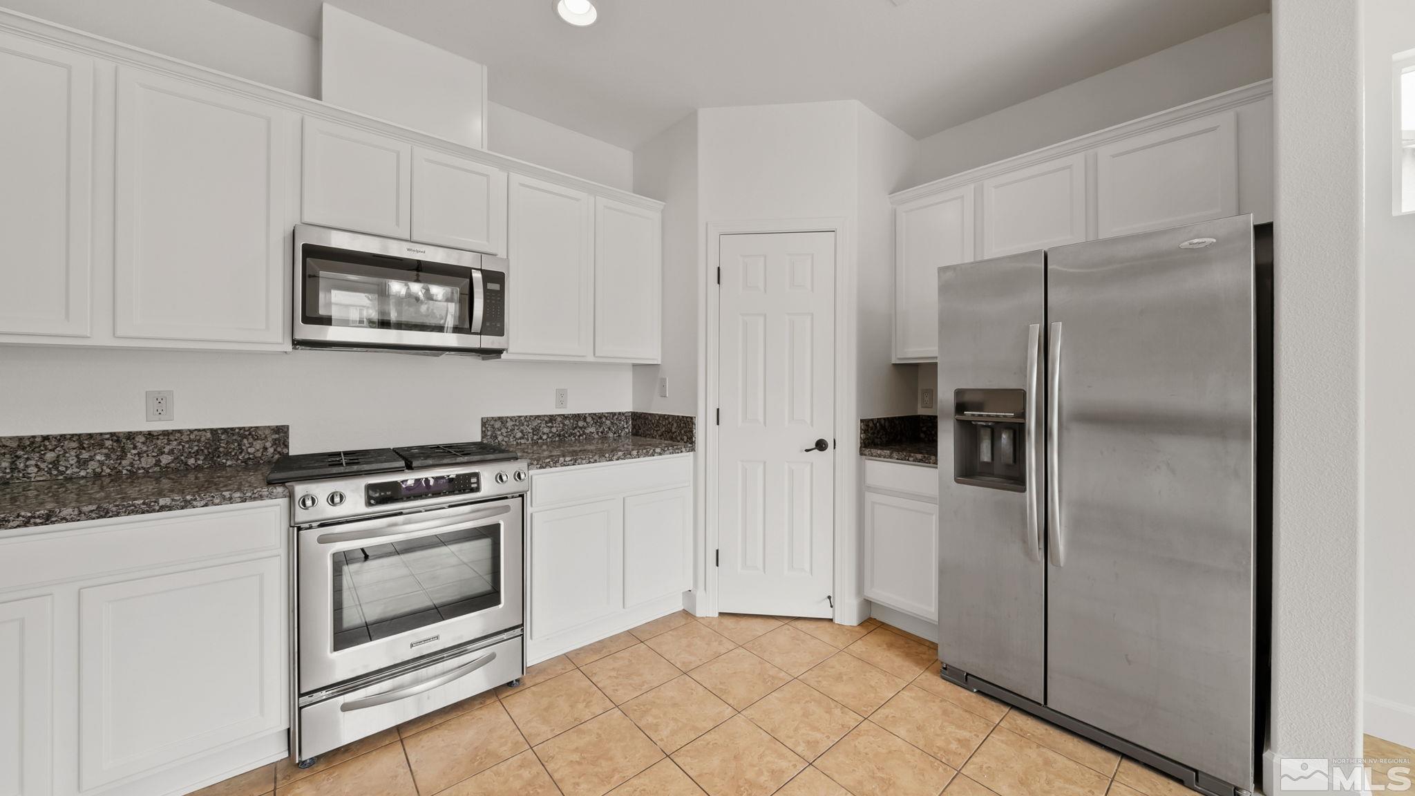 11074 Colton Drive Reno, NV 89521 - Photo 20 of 28 a kitchen with cabinets and stainless steel appliances