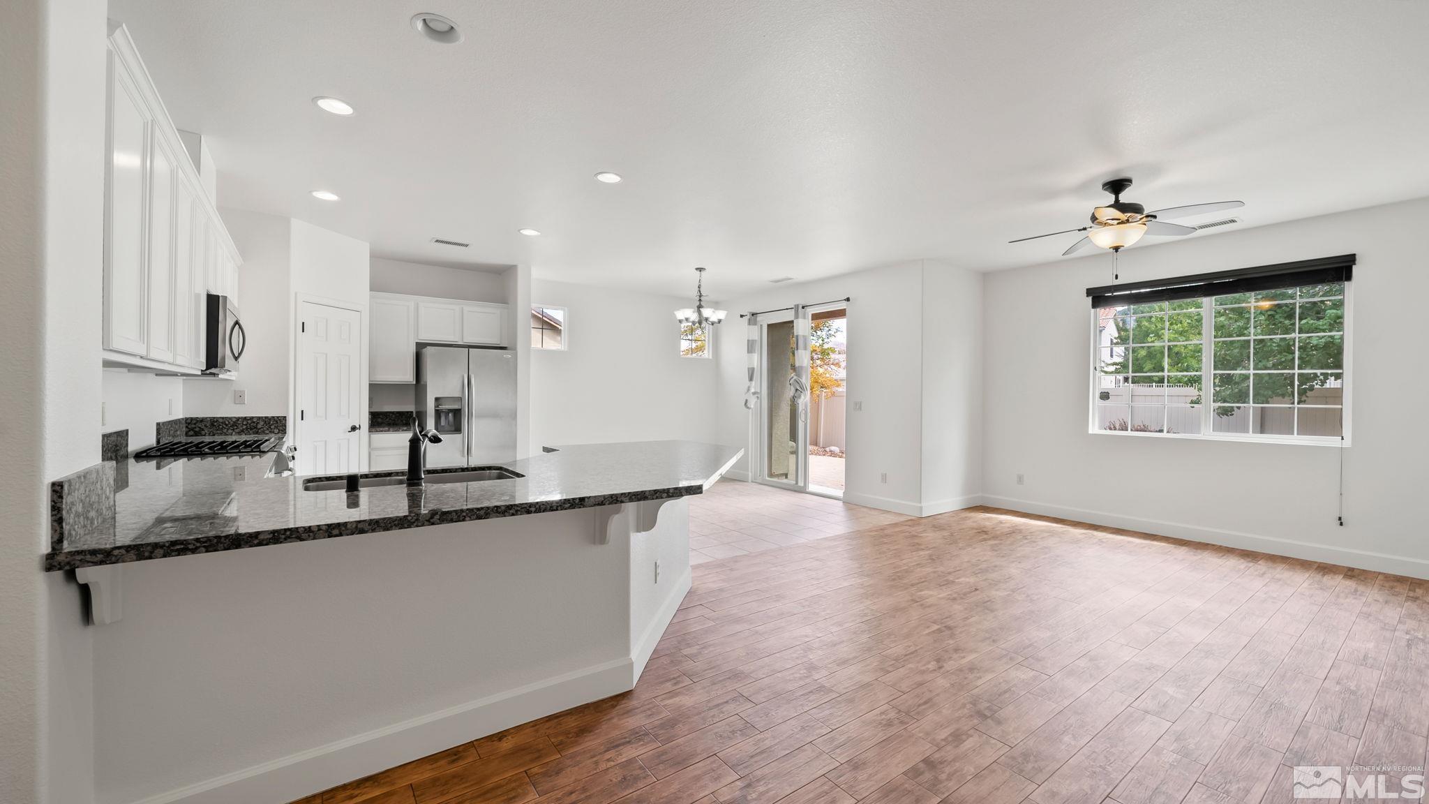 11074 Colton Drive Reno, NV 89521 - Photo 10 of 28 a large kitchen with granite countertop a sink a counter top space stainless steel appliances and a window