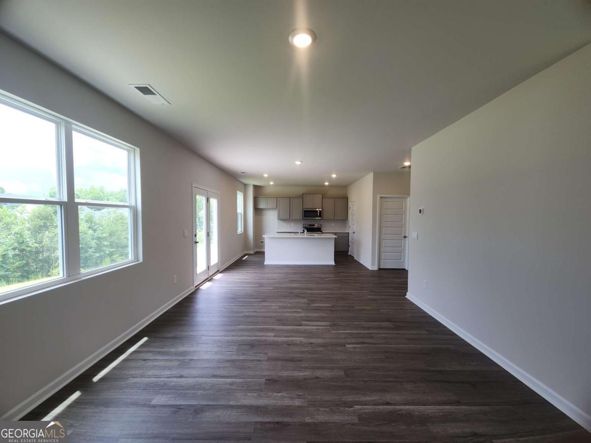 146 Aster Avenue Locust Grove, GA 30248 - Photo 13 of 25 a view of a big room with wooden floor and a window