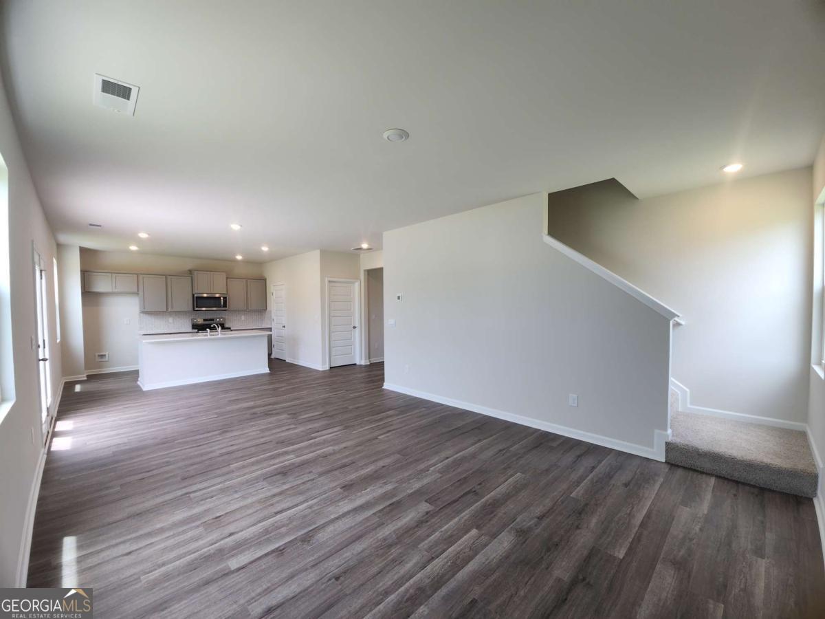 146 Aster Avenue Locust Grove, GA 30248 - Photo 14 of 25 a view of a big room with wooden floor and windows