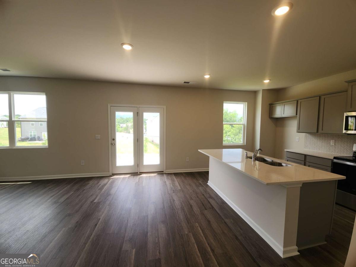146 Aster Avenue Locust Grove, GA 30248 - Photo 10 of 25 a living room with stainless steel appliances granite countertop furniture wooden floor and a window