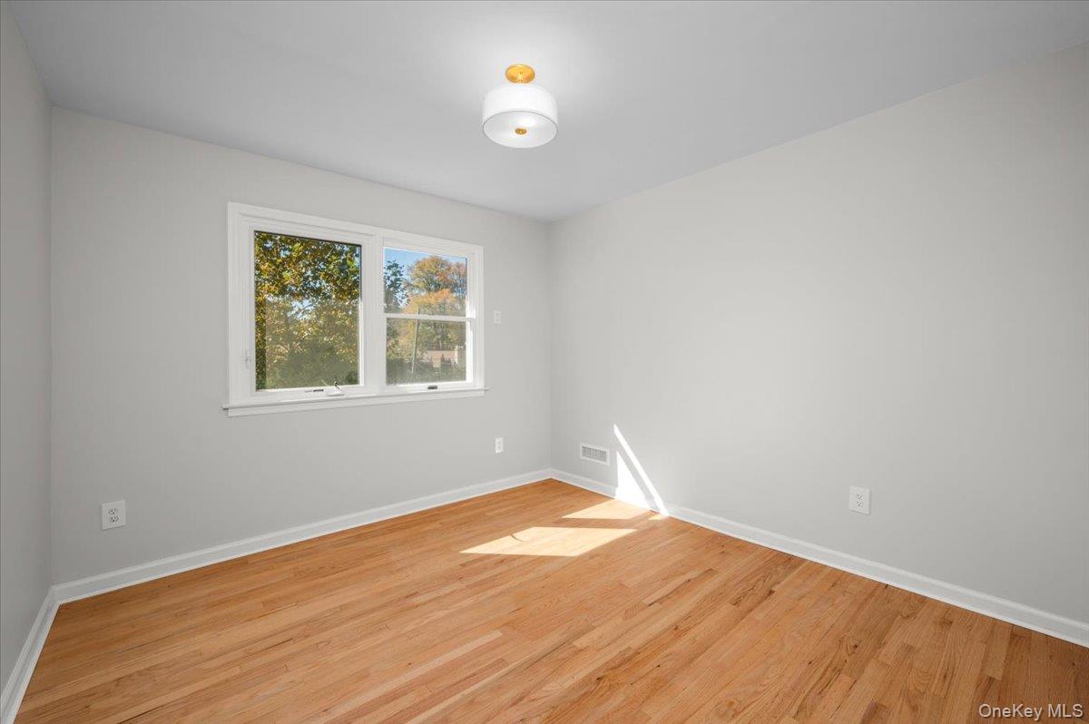 15 Hillside Road Bronxville, NY 10708 - Photo 18 of 30 a view of empty room with wooden floor and fan