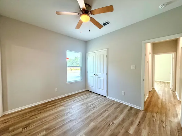 a view of an empty room and window and a ceiling fan