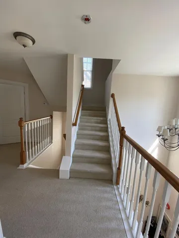 a view of staircase with lots of frames on wall and stairs
