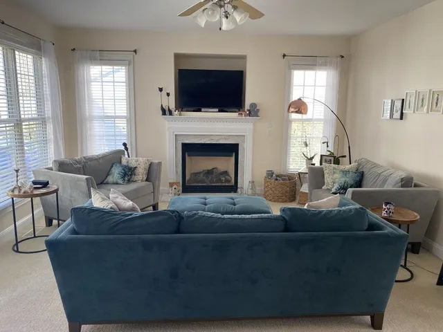 a living room with furniture a flat screen tv and a fireplace