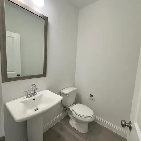 a bathroom with a sink a toilet and mirror