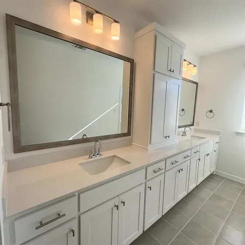 a bathroom with a double vanity sink and a mirror