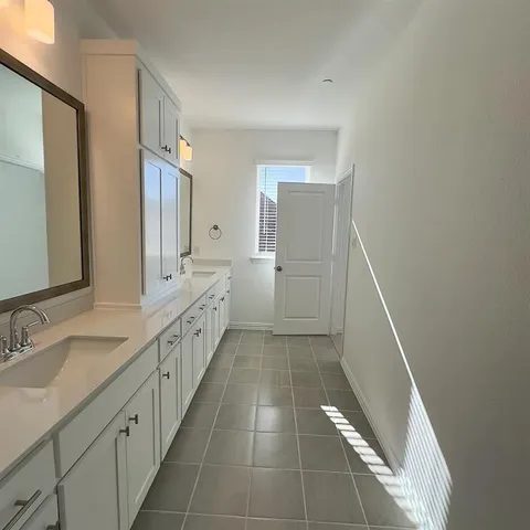 a bathroom with a double vanity sink and a mirror