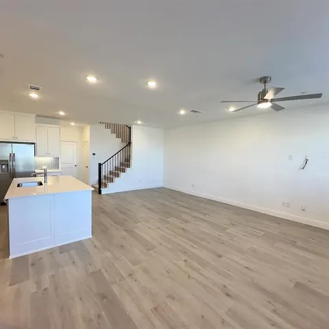 a view of a kitchen with a sink and a ceiling fan