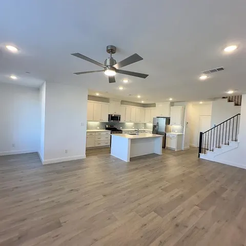 a view of kitchen with kitchen island stainless steel appliances sink cabinets and window