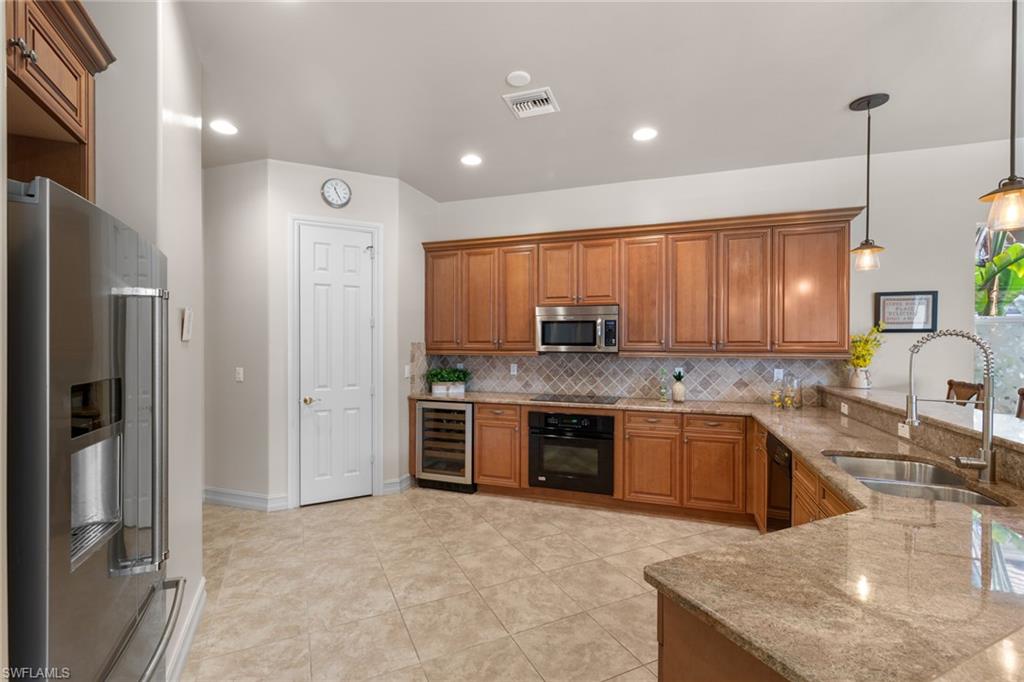 20060 Markward Crossing Estero, FL 33928 - Photo 23 of 50 a large kitchen with granite countertop a large counter top stainless steel appliances and cabinets