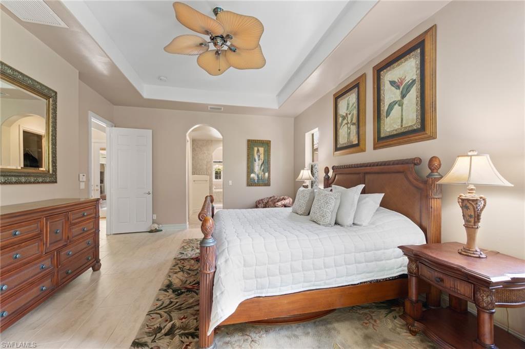 20060 Markward Crossing Estero, FL 33928 - Photo 34 of 50 a bedroom with a large bed and a chandelier