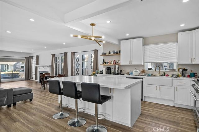 a kitchen with stainless steel appliances kitchen island granite countertop a stove a sink a dining table and chairs