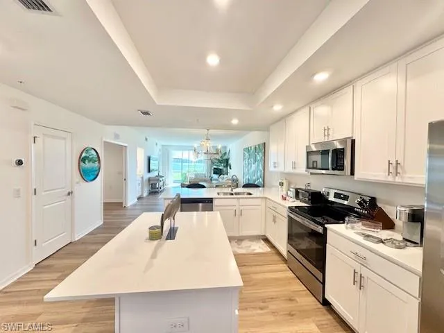 a large kitchen with stainless steel appliances kitchen island granite countertop a sink and cabinets