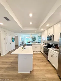 a large kitchen with stainless steel appliances kitchen island a stove a refrigerator a oven and a sink with large countertops