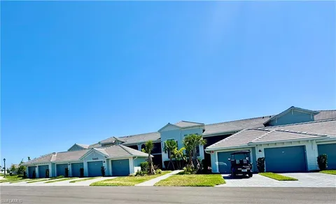 a front view of a house with a yard and potted plants