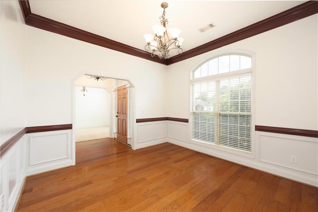8 Ridgebrook Drive Phenix City, AL 36869 - Photo 4 of 21 Spare room with a chandelier, wainscoting, crown molding, light wood-type flooring, and a decorative wall