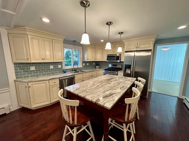 a kitchen with stainless steel appliances granite countertop wooden floor window and cabinets