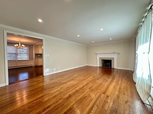 a view of empty room with wooden floor and fireplace