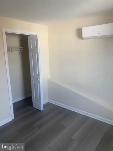 an empty room with wooden floor and entrance