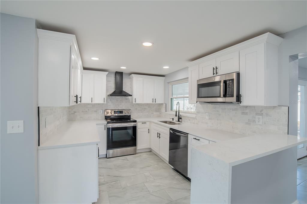 616 Highview Circle North Brandon, FL 33510 - Photo 6 of 41 a kitchen with stainless steel appliances granite countertop a stove a sink and a microwave