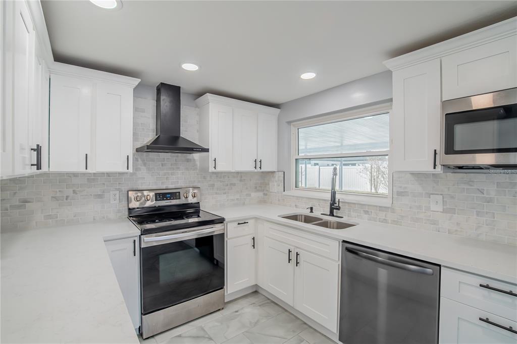 616 Highview Circle North Brandon, FL 33510 - Photo 7 of 41 a kitchen with stainless steel appliances granite countertop a sink stove a microwave and cabinets