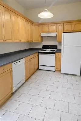 a kitchen with granite countertop a stove a sink and a refrigerator